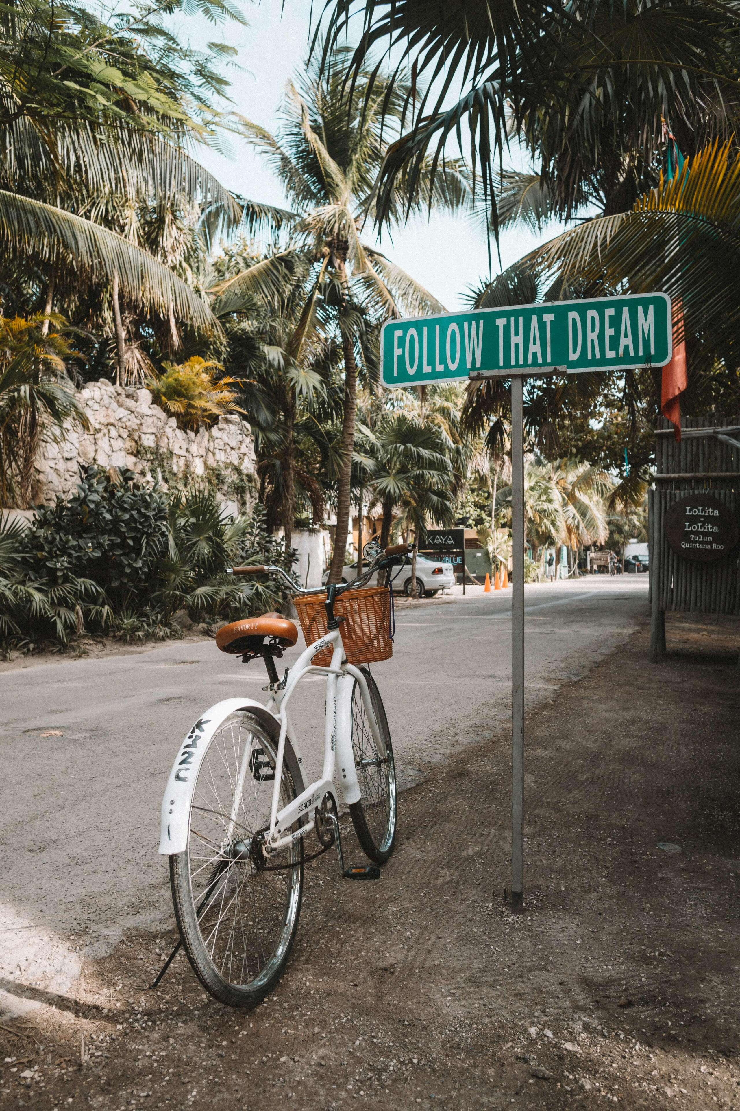 Bicycle with inspirational sign about following your dreams A peaceful travel-inspired image representing freedom, manifestation, personal growth and creating a life that feels aligned with your true desires.