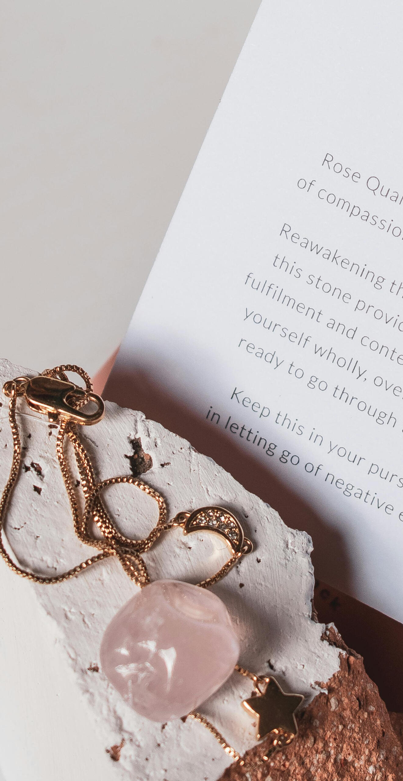 This is a photo of a Rose Quartz necklace with a description of the healing properties of Rose Quartz crystal